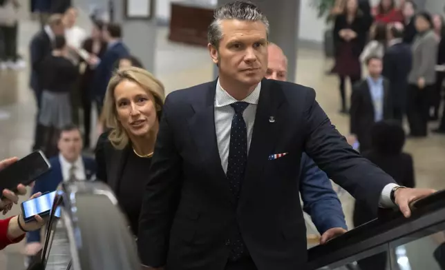 Pete Hegseth, President-elect Donald Trump's nominee to be defense secretary, is joined by his wife Jennifer Rauchet, as they walk through the basement of the Capitol, Wednesday, Dec. 4, 2024, in Washington. (AP Photo/Mark Schiefelbein)