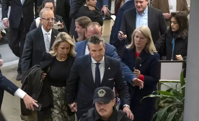 Pete Hegseth, President-elect Donald Trump's nominee to be defense secretary, in black tie, walks through the basement of the Capitol, Wednesday, Dec. 4, 2024, in Washington. (AP Photo/Mark Schiefelbein)