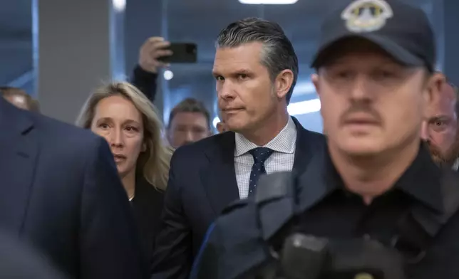 Pete Hegseth, President-elect Donald Trump's nominee to be defense secretary, is joined by his wife Jennifer Rauchet, as they walk through the basement of the Capitol, Wednesday, Dec. 4, 2024, in Washington. (AP Photo/Mark Schiefelbein)