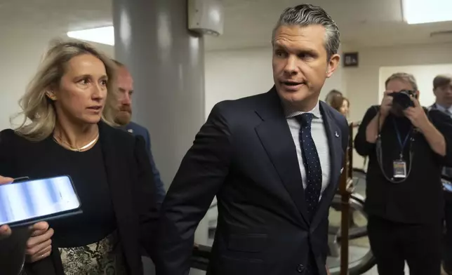 Pete Hegseth, President-elect Donald Trump's nominee to be defense secretary, is joined by his wife Jennifer Rauchet, as they walk through the basement of the Capitol, Wednesday, Dec. 4, 2024, in Washington. (AP Photo/Mark Schiefelbein)