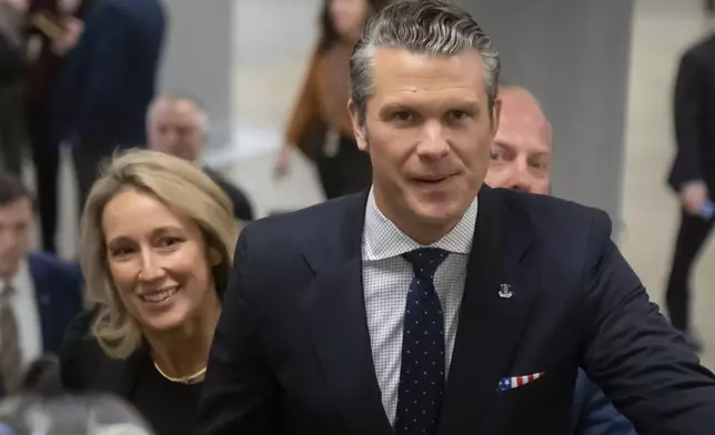 Pete Hegseth, President-elect Donald Trump's nominee to be defense secretary, is joined by his wife Jennifer Rauchet, as they walk through the basement of the Capitol, Wednesday, Dec. 4, 2024, in Washington. (AP Photo/Mark Schiefelbein)