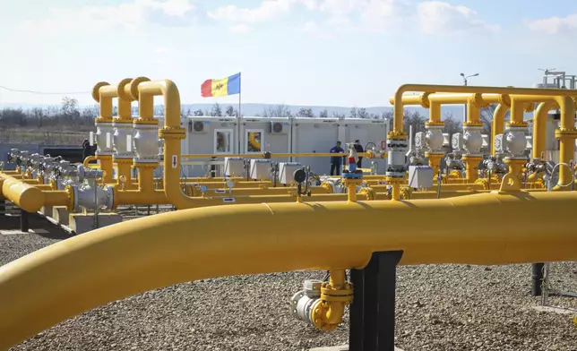 FILE - Men stand next to pipelines of the national natural gas distribution network outside Ungheni, Moldova, March 4, 2015. (AP Photo/Aurel Obreja, File)