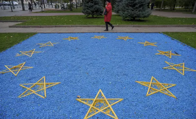 FILE - A woman walks by a depiction of the European Union flag near a park in central Chisinau, Moldova, Oct. 17, 2024. (AP Photo/Vadim Ghirda, File)