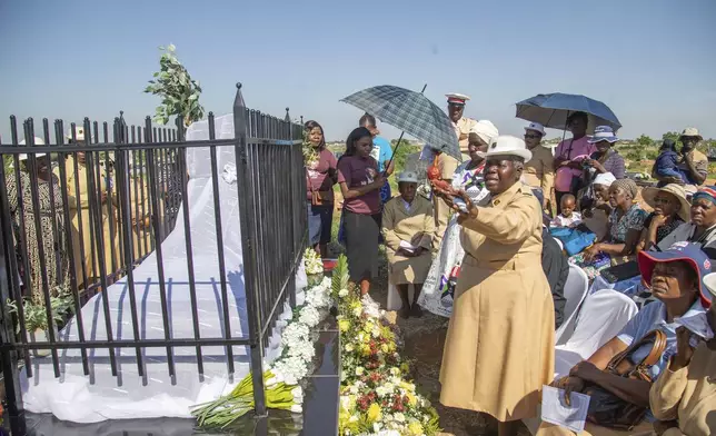 Friends and relatives of the Ziwangwe family, during the unveiling of the tombstone of late Kindness Ziwangwe at a cemetary in Harare, Zimbabwe, Saturday, Dec 7, 2024. (AP Photo/Aaron Ufumeli)