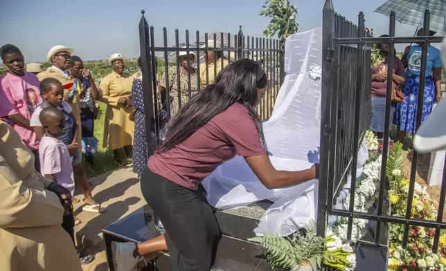 Friends and relatives of the Ziwangwe family, during the unveiling of the tombstone of late Kindness Ziwangwe at a cemetary in Harare, Zimbabwe, Saturday, Dec 7, 2024. (AP Photo/Aaron Ufumeli)