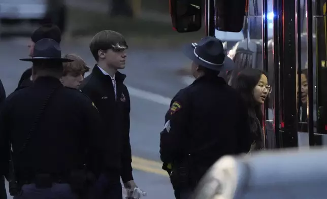 Students aboard a bus as they leave the shelter following a shooting at the Abundant Life Christian School, Monday, Dec. 16, 2024. (AP Photo/Morry Gash)