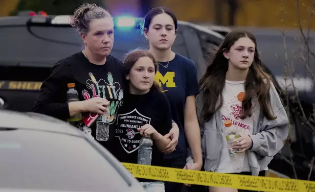 A family leave the shelter after multiple injuries were reported following a shooting at the Abundant Life Christian School, Monday, Dec. 16, 2024. (AP Photo/Morry Gash)