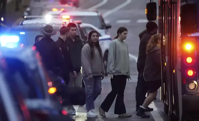 Students aboard a bus as they leave the shelter following a shooting at the Abundant Life Christian School, Monday, Dec. 16, 2024. (AP Photo/Morry Gash)