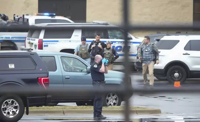 Police investigate as emergency vehicles are parked outside the Abundant Life Christian School in Madison, Wis., where multiple injuries were reported following a shooting, Monday, Dec. 16, 2024. (AP Photo/Morry Gash)