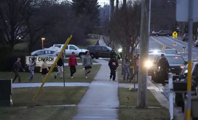 Students walk to a bus as they leave the shelter following a shooting at the Abundant Life Christian School, Monday, Dec. 16, 2024. (AP Photo/Morry Gash)