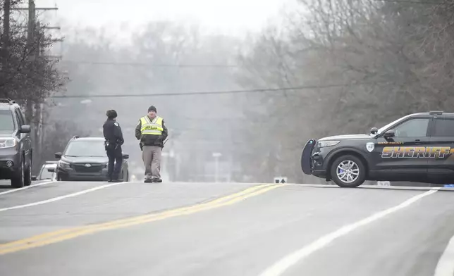 Police guard as emergency vehicles are parked outside the Abundant Life Christian School in Madison, Wis., where multiple injuries were reported following a shooting, Monday, Dec. 16, 2024. (AP Photo/Morry Gash)