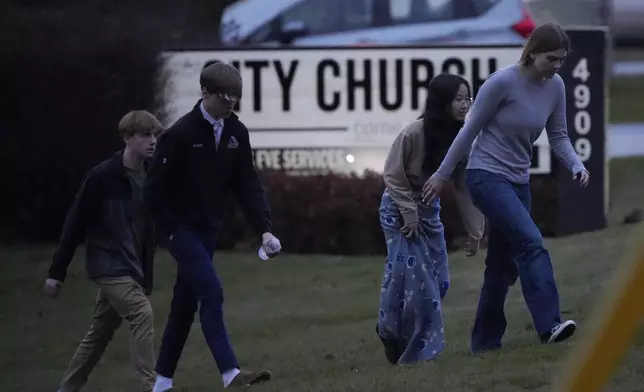 Students walk to a bus as they leave the shelter following a shooting at the Abundant Life Christian School, Monday, Dec. 16, 2024. (AP Photo/Morry Gash)