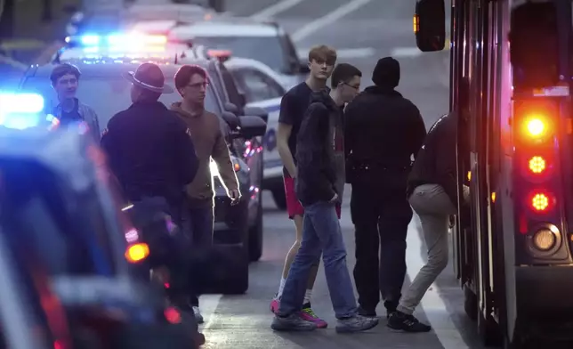 Students aboard a bus as they leave the shelter following a shooting at the Abundant Life Christian School, Monday, Dec. 16, 2024. (AP Photo/Morry Gash)