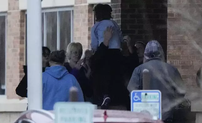 A child run to the family as they were reunited at the reunification center following a shooting at the Abundant Life Christian School, Monday, Dec. 16, 2024. (AP Photo/Morry Gash)