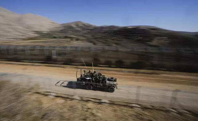 Israeli soldiers stand on an armoured vehicle after crossing the security fence along the so-called Alpha Line that separates the Israeli-controlled Golan Heights from Syria, in the town of Majdal Shams, Tuesday, Dec. 17, 2024. (AP Photo/Matias Delacroix)