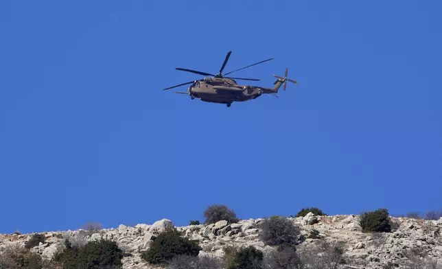 An Israeli Air Force Black Hawk helicopter flies over Mount Hermon near the so-called Alpha Line that separates the Israeli-controlled Golan Heights from Syria, viewed from the town of Majdal Shams, Tuesday, Dec. 17, 2024. (AP Photo/Matias Delacroix)