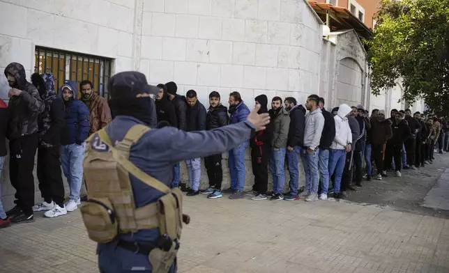 Members from Bashar Assad's Syrian army period line up to register with Syrian rebels as part of a "identification and reconciliation process" at a army compound in Latakia, Syria, Tuesday Dec. 17, 2024.(AP Photo/Leo Correa)