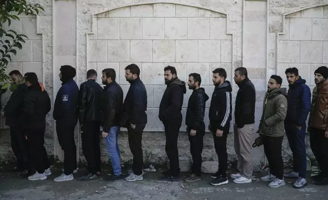 Members of Bashar Assad's army or pro-government militias line up to register with Syrian rebels as part of an "identification and reconciliation" process at an army compound in Latakia, Syria, Tuesday, Dec. 17, 2024. (AP Photo/Leo Correa)