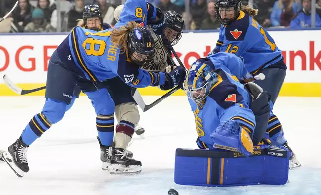 Toronto Sceptres goaltender Raygan Kirk gets down to drop on the puck as Sceptres's Jesse Compher tangles with Montreal Victoire's Kristen O'Neill during first period of a PWHL hockey game in Toronto, Saturday, Dec. 21, 2024. (Chris Young /The Canadian Press via AP)