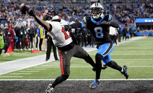 Carolina Panthers cornerback Jaycee Horn breaks up a pass intended for Tampa Bay Buccaneers wide receiver Sterling Shepard during the first half of an NFL football game, Sunday, Dec. 1, 2024, in Charlotte, N.C. (AP Photo/Jacob Kupferman)