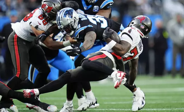 Tampa Bay Buccaneers running back Bucky Irving is tackled by the Carolina Panthers during the first half of an NFL football game, Sunday, Dec. 1, 2024, in Charlotte, N.C. (AP Photo/Rusty Jones)