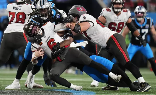 Tampa Bay Buccaneers quarterback Baker Mayfield is sacked by Carolina Panthers during overtime an NFL football game, Sunday, Dec. 1, 2024, in Charlotte, N.C. (AP Photo/Rusty Jones)