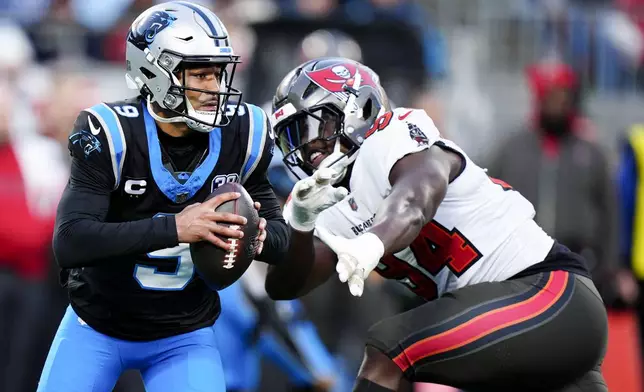 Carolina Panthers quarterback Bryce Young runs past Tampa Bay Buccaneers defensive tackle Calijah Kancey during the first half of an NFL football game, Sunday, Dec. 1, 2024, in Charlotte, N.C. (AP Photo/Jacob Kupferman)