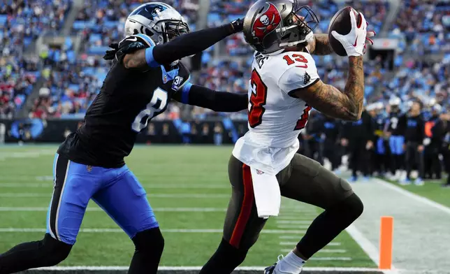 Tampa Bay Buccaneers wide receiver Mike Evans catches a touchdown pass ahead of Carolina Panthers cornerback Jaycee Horn during the first half of an NFL football game, Sunday, Dec. 1, 2024, in Charlotte, N.C. (AP Photo/Jacob Kupferman)