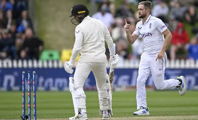 England bowler Chris Woakes celebrates the wicket of New Zealand batsman Devon Conway, left, during play on day three of the second cricket test between New Zealand and England at the Basin Reserve in Wellington, New Zealand, Sunday, Dec.8, 2024. (Andrew Cornaga/Photosport via AP)