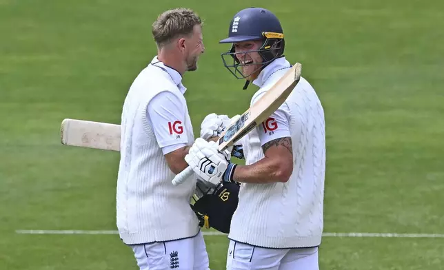 England's Ben Stokes, right, reacts as teammate Joe Root scores a century during play on day three of the second cricket test between New Zealand and England at the Basin Reserve in Wellington, New Zealand, Sunday, Dec.8, 2024.(Kerry Marshall/Photosport via AP)