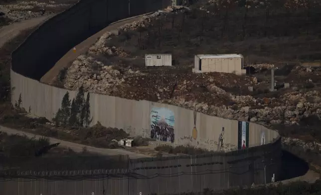 A wall marks the Israeli-Lebanese border near the village of Odaisseh in southern Lebanon, as seen from northern Israel, Sunday, Dec. 1, 2024. (AP Photo/Leo Correa)