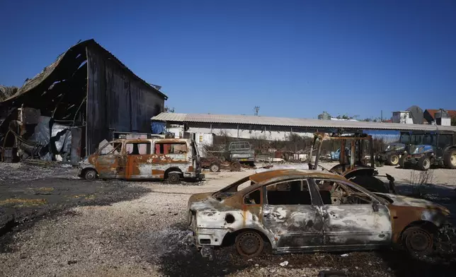 Burned-out cars and buildings from Hezbollah rockets are seen in the agricultural settlement of Avivim, near the Lebanese border in the Upper Galilee, Israel, on Monday Dec. 2, 2024. Despite the ceasefire with Hezbollah, Israelis remain wary of returning to the north. (AP Photo/Ohad Zwigenberg)