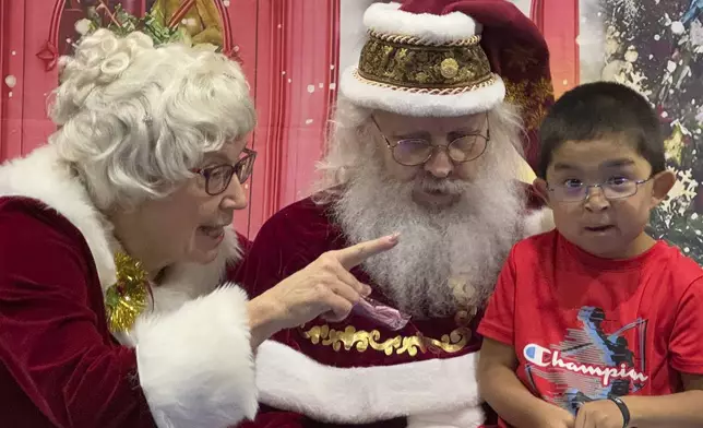 Santa and Mrs. Claus talk to a child in Yakutat, Alaska, in the Alaska National Guard's Operation Santa program, Wednesday, Dec. 18, 2024. (AP Photo/Mark Thiessen)