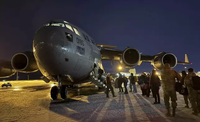 Participants in the Operation Santa program board an Alaska Air National Guard C-17 Globemaster III at Joint Base Elmendorf-Richardson, Alaska, to deliver Santa and Mrs. Claus to Yakutat, Alaska, Wednesday, Dec. 18, 2024. (AP Photo/Mark Thiessen).