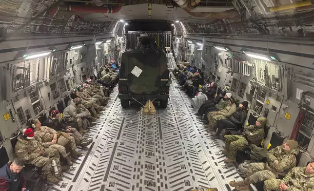 Two Humvees and participants in the Operation Santa program aboard an Alaska Air National Guard C-17 Globemaster III plane also delivering Santa and Mrs. Claus to Yakutat, Alaska, Wednesday, Dec. 18, 2024. (AP Photo/Mark Thiessen).