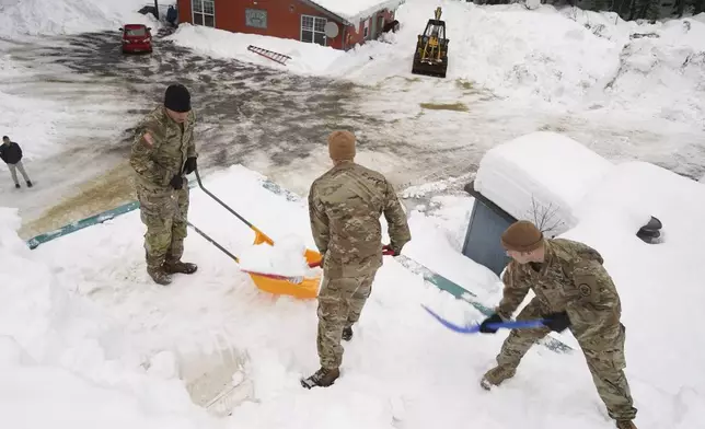 Alaska National Guard soldiers and airmen shovel the roof of a building in Yakutat, Alaska. (Photo by Dana Rosso, U.S. Army National Guard via AP)