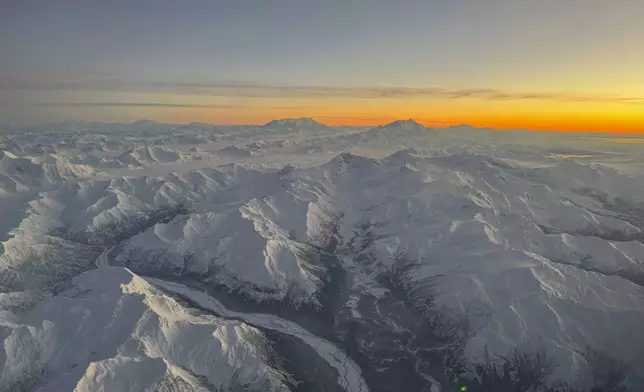 Snow-capped mountains out a side window in the cockpit of an Alaska Air National Guard C-17 Globemaster III as it nears Yakutat, Alaska, Jan. 12, 2022. (AP Photo/Mark Thiessen)