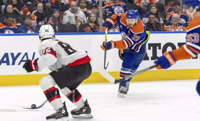 Edmonton Oilers' Leon Draisaitl (29) has his shot deflected off the stick of Ottawa Senators' Jake Sanderson (85) during second-period NHL hockey game action in Edmonton, Alberta, Sunday, Dec. 22, 2024. (Timothy Matwey/The Canadian Press via AP)