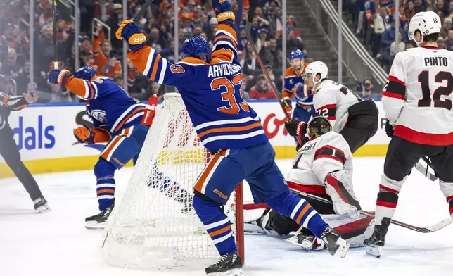 Edmonton Oilers' Viktor Arvidsson (33) celebrates after a goal by teammate Zach Hyman (18) against the Ottawa Senators during second-period NHL hockey game action in Edmonton, Alberta, Sunday, Dec. 22, 2024. (Timothy Matwey/The Canadian Press via AP)