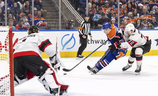 Edmonton Oilers' Vasily Podkolzin, second from right, drives to the net against Ottawa Senators' Thomas Chabot (72) during second-period NHL hockey game action in Edmonton, Alberta, Sunday, Dec. 22, 2024. (Timothy Matwey/The Canadian Press via AP)