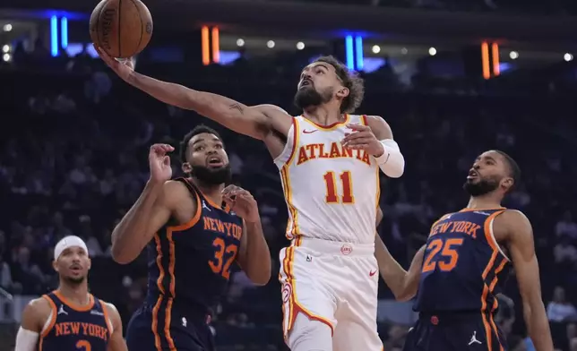 Atlanta Hawks' Trae Young (11) drives past New York Knicks' Mikal Bridges (25), Karl-Anthony Towns (32) and Josh Hart (3) during the first half of an Emirates NBA Cup basketball game Wednesday, Dec. 11, 2024, in New York. (AP Photo/Frank Franklin II)