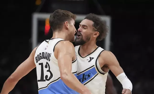 Atlanta Hawks guard Bogdan Bogdanovic (13) reacts with teammate Atlanta Hawks guard Trae Young (11) after scoring In the second half of an NBA basketball game against the Los Angeles Lakers, Friday, Dec. 6, 2024, in Atlanta. (AP Photo/Brynn Anderson)