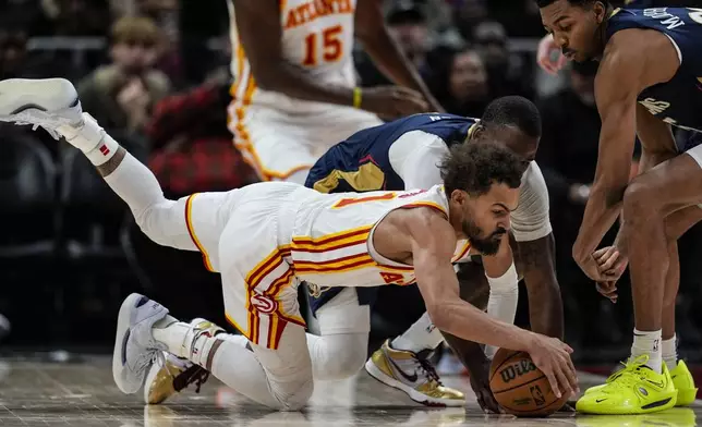 Atlanta Hawks guard Trae Young (11) vies for a loose ball with New Orleans Pelicans guard Javonte Green (4) during the first half of an NBA basketball game, Monday, Dec. 2, 2024, in Atlanta. (AP Photo/Mike Stewart)