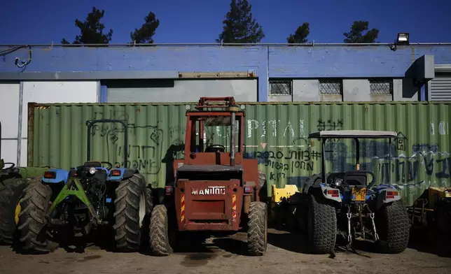 Tractors are parked next to a mechanic shop in the kibbutz of Ein Zivan in the Israeli-annexed Golan Heights, which most of the world considers occupied Syrian territory, Thursday, Dec. 19, 2024. (AP Photo/Matias Delacroix)