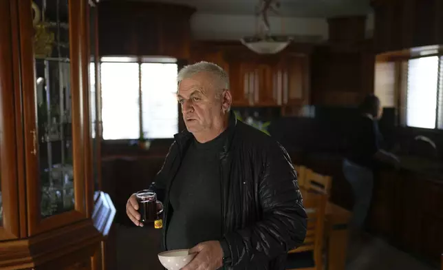 Ali Abu Awad holds a cup of tea inside his house in Masada in the Israeli-annexed Golan Heights, which most of the world considers occupied Syrian territory, Thursday, Dec. 19, 2024. (AP Photo/Matias Delacroix)