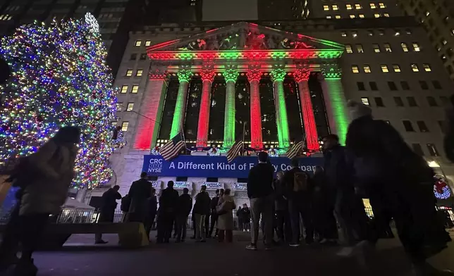 People gather in front of the New York Stock Exchange in New York's Financial District on Tuesday, Dec. 10, 2024. (AP Photo/Peter Morgan)