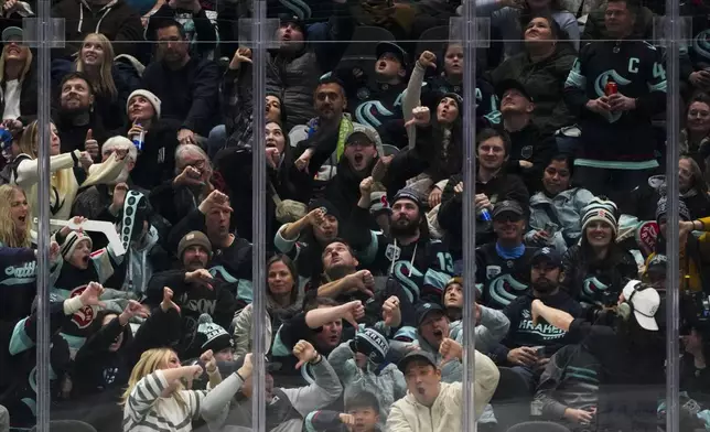 Seattle Kraken fans react after a goal by center Matty Beniers against the San Jose Sharks was disallowed due to goaltender interference during the third period of an NHL hockey game Saturday, Nov. 30, 2024, in Seattle. The Sharks won 4-2. (AP Photo/Lindsey Wasson)