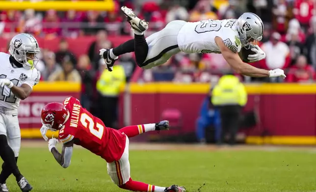 Las Vegas Raiders tight end Brock Bowers (89) tries to leap over Kansas City Chiefs cornerback Joshua Williams (2) during the first half of an NFL football game in Kansas City, Mo., Friday, Nov. 29, 2024. (AP Photo/Ed Zurga)