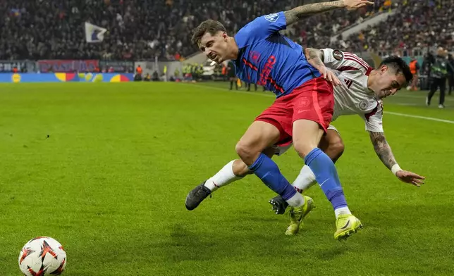 Olympiacos' Francisco Ortega, right, challenges for the ball with FCSB's David Miculescu during the Europa League league phase soccer match between FCSB and Olympiacos at the National Arena stadium, in Bucharest, Romania, Thursday, Nov. 28, 2024. (AP Photo/Andreea Alexandru)