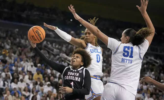 South Carolina guard Maddy McDaniel (1) drives to the basket against UCLA forward Janiah Barker (0) and center Lauren Betts (51) during the first half of an NCAA college basketball game, Sunday, Nov. 24, 2024, in Los Angeles. (AP Photo/Eric Thayer)